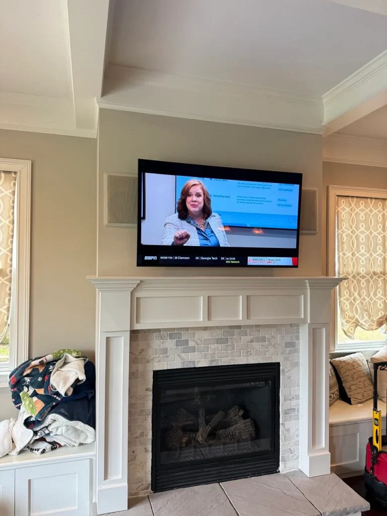tv mounted above fireplace in living room with clean installation Atlanta