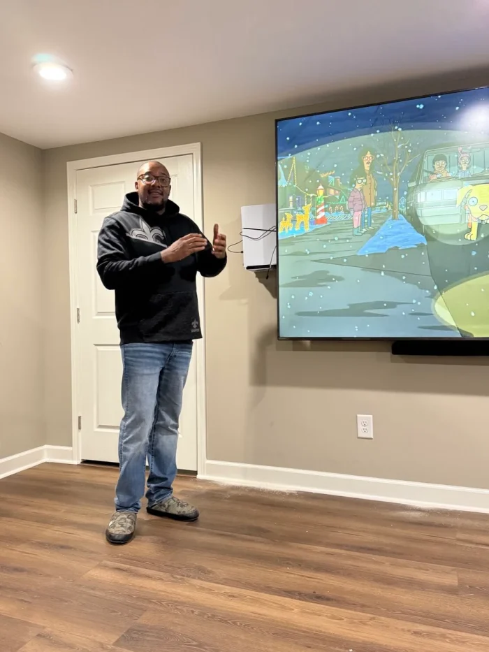 a man standing in front of a large screen